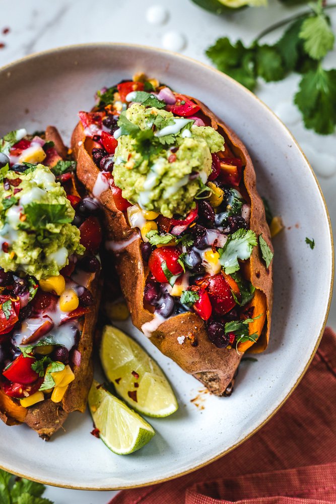 Black Bean Stuffed Sweet Potatoes are easy to make. This is Mexican inspired with fresh ingredients like corn, tomato, cilantro and guacamole. 