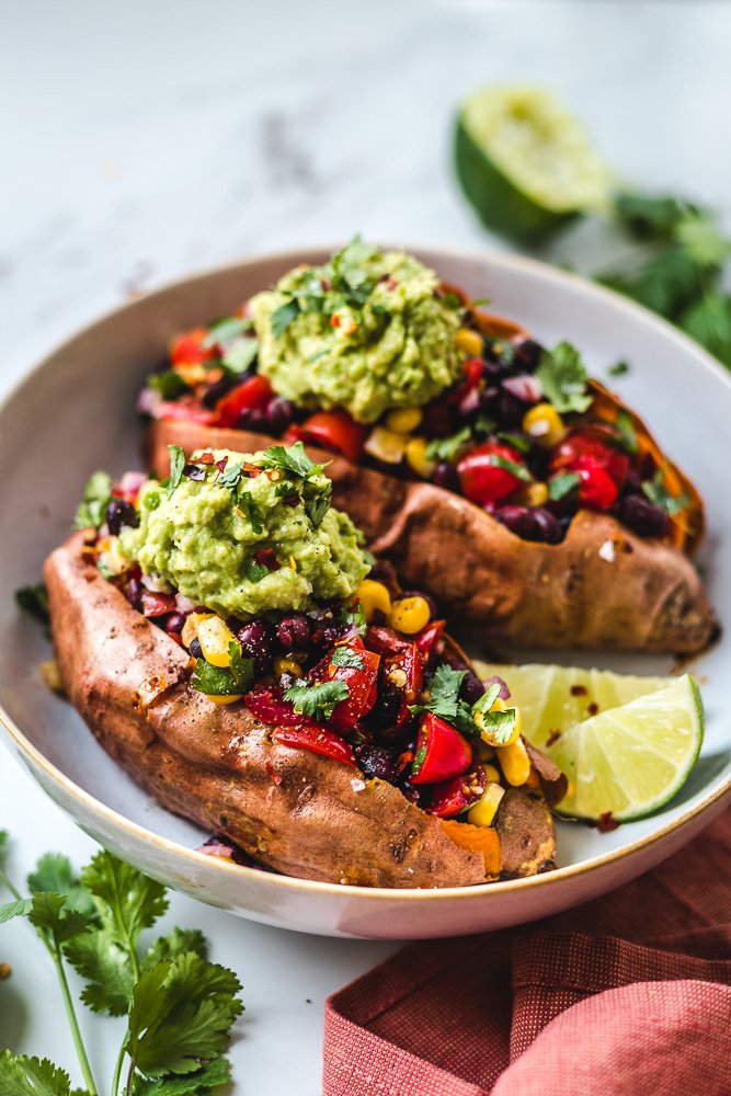 Black Bean Stuffed Sweet Potatoes are easy to make. This is Mexican inspired with fresh ingredients like corn, tomato, cilantro and guacamole. 